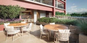 Área de churrasqueira do condomínio Reserva Ubiatans com mesas na bancada e mais mesas na área externa