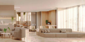 Belo salão de festas dentro do condomínio Reserva Ubiatans com mesas, sofás em tons claros em amplo salão com bastante iluminação natural